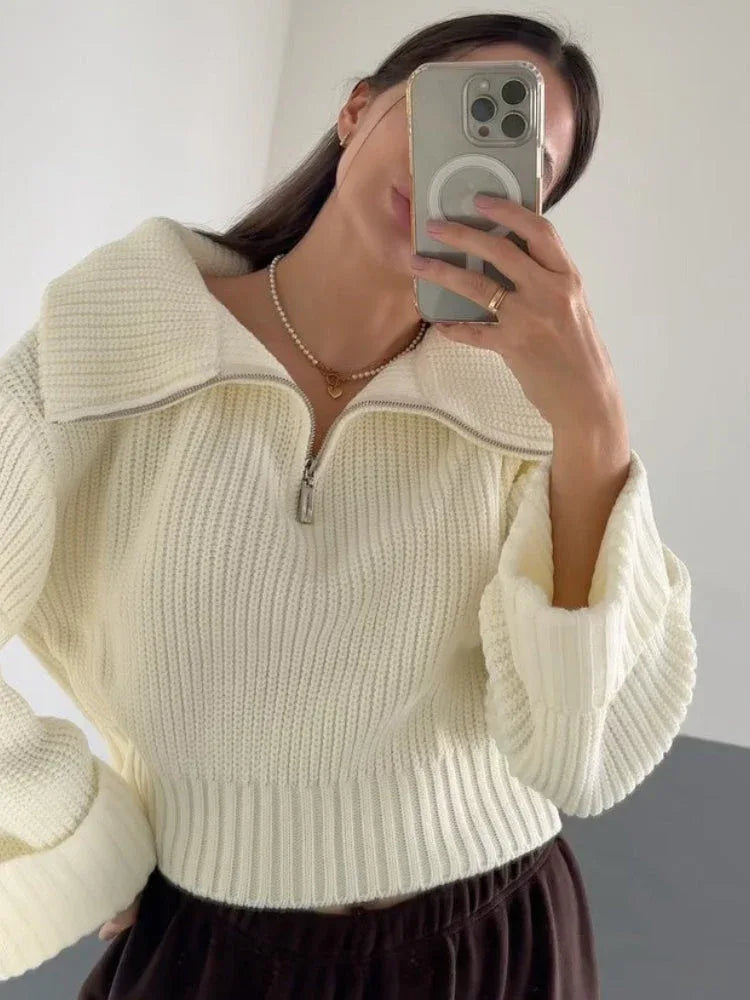 Woman taking a selfie in a cream-colored oversized knit sweater with a half-zip neckline and wide sleeves.