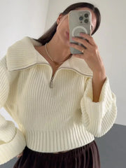 Woman taking a selfie in a cream-colored oversized knit sweater with a half-zip neckline and wide sleeves.