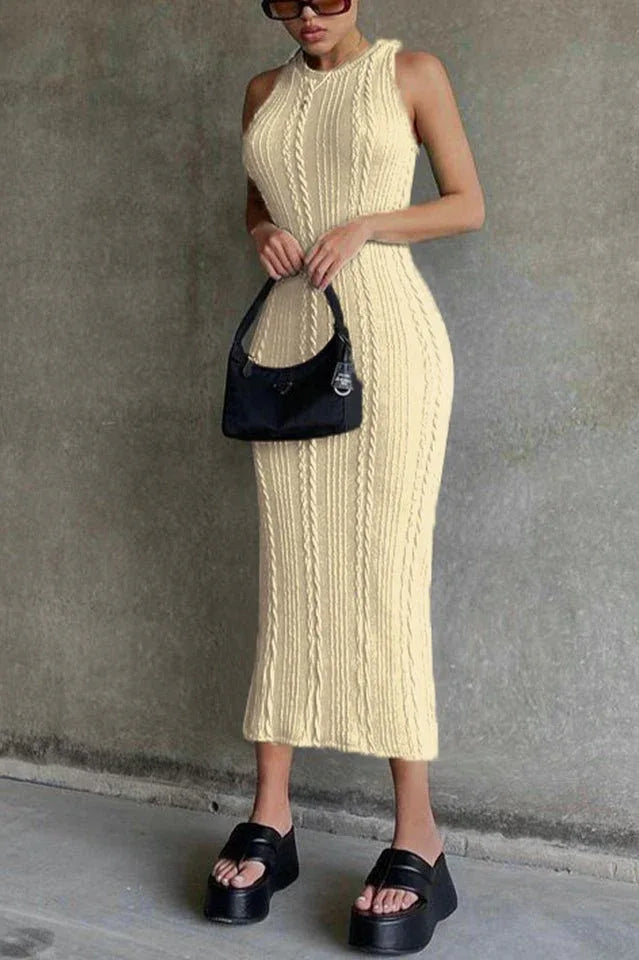 Woman wearing a cream sleeveless cable knit midi dress, black platform sandals, and a black handbag.