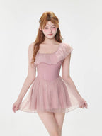 Front view of a woman modeling a pink one-shoulder swimsuit with a sheer skirt overlay.