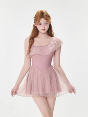 Front view of a woman modeling a pink one-shoulder swimsuit with a sheer skirt overlay.