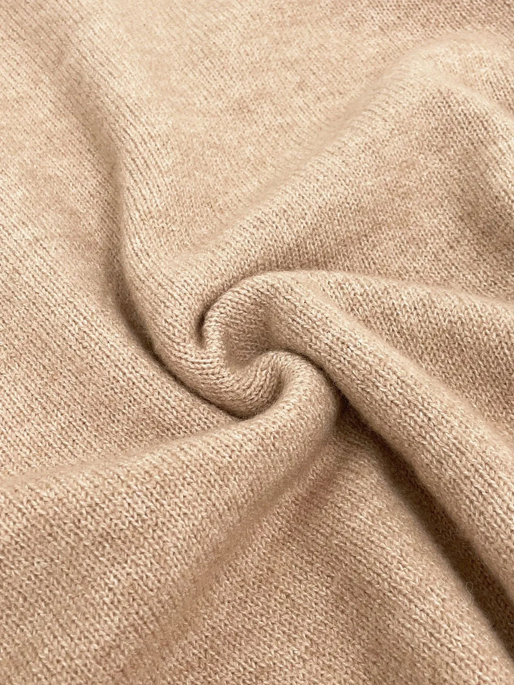 Close-up of the textured knit fabric of a beige sweater.