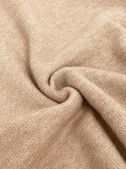 Close-up of the textured knit fabric of a beige sweater.
