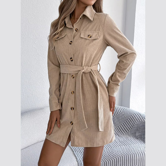 Full shot of a woman in a tan corduroy shirt dress, showcasing the button-down front and belted detail.
