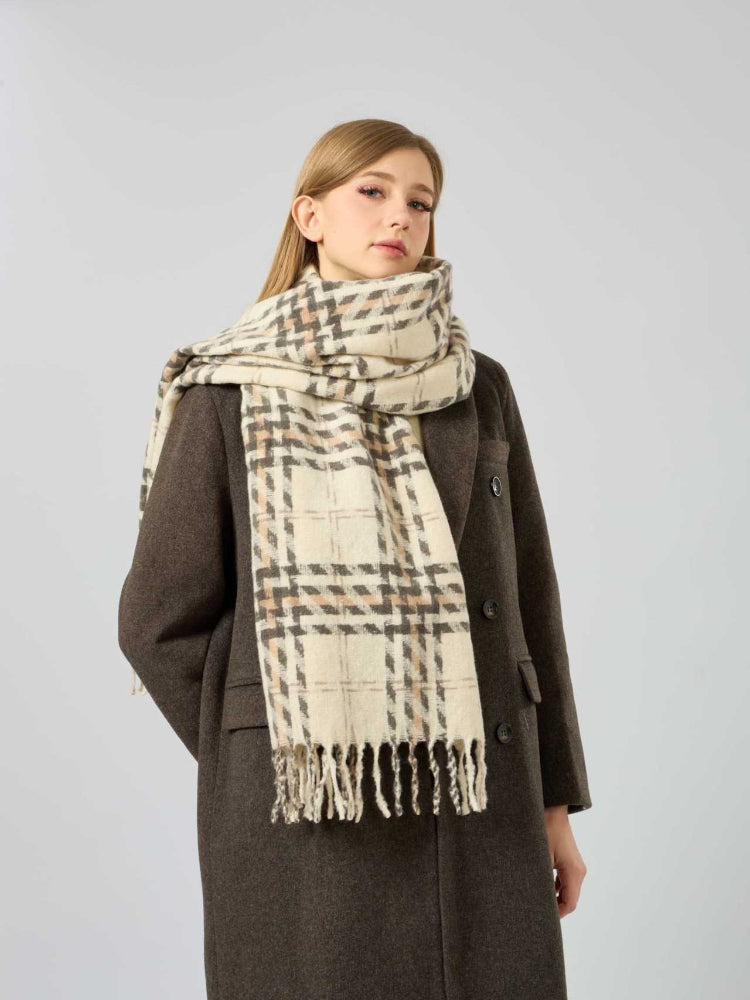 Woman wearing a brown coat and a cream, brown, and grey plaid scarf