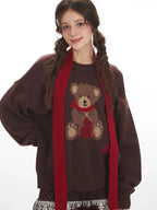 Close-up of the teddy bear graphic on a brown knit sweater