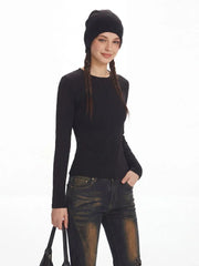 Model smiling and wearing a black ribbed knit top and distressed flared jeans with fur trim cuffs.