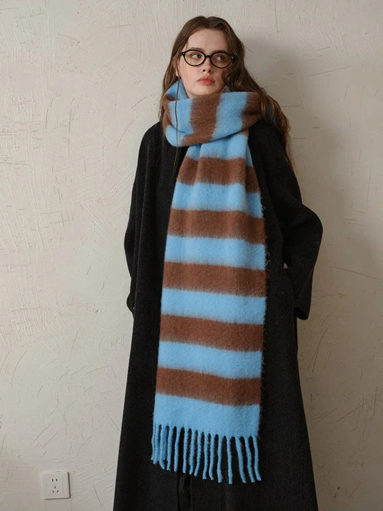 Close-up of a woman wearing a black coat and a blue and brown striped scarf