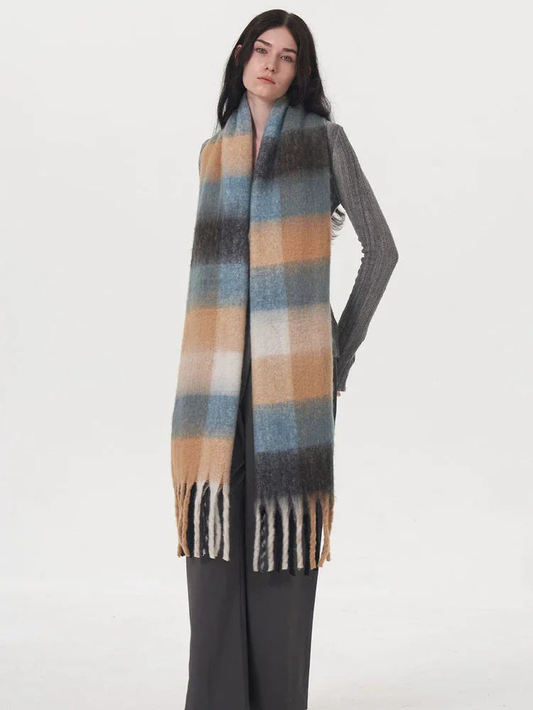 Side view of a model wearing a grey sweater and plaid scarf