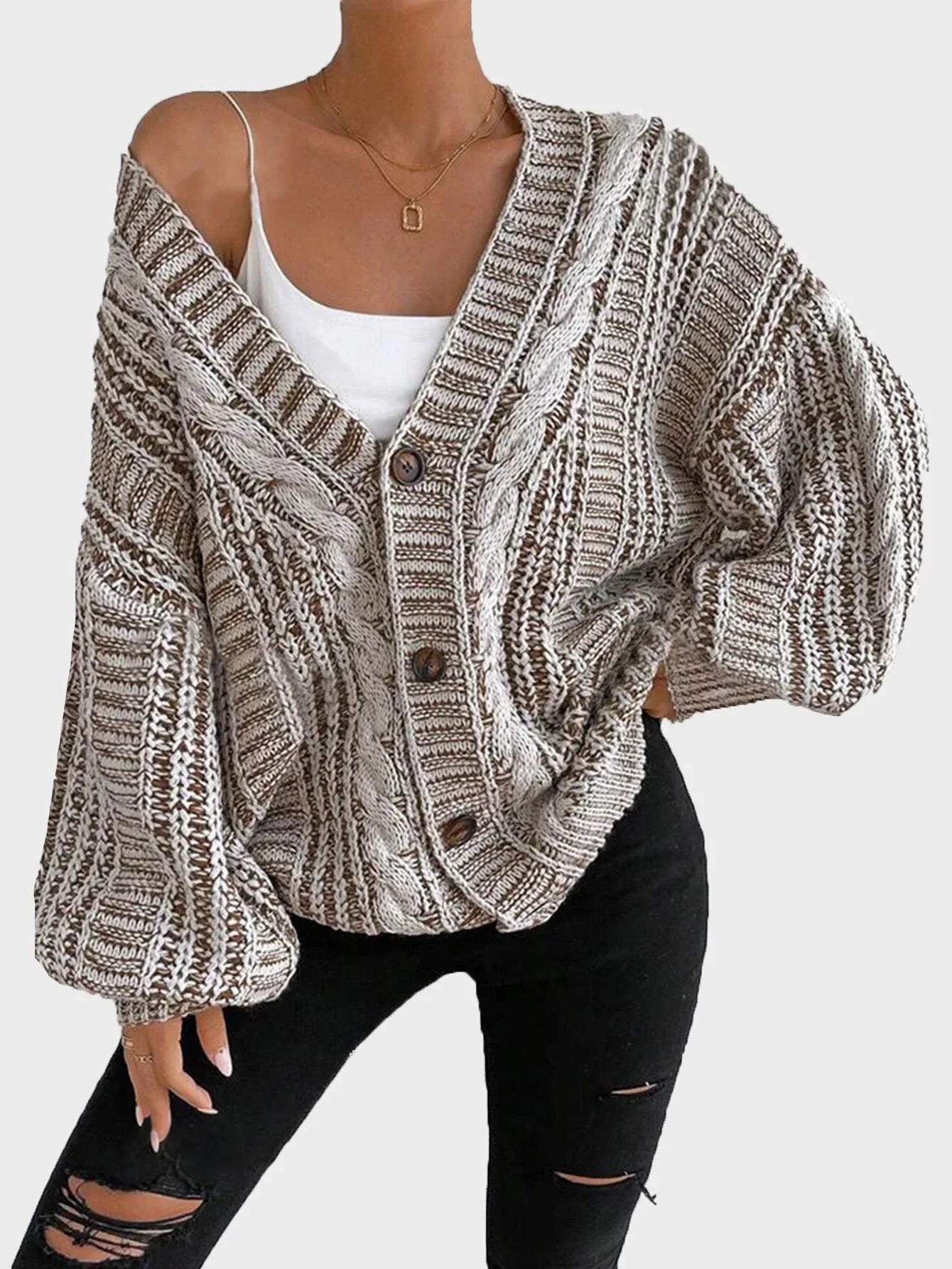 Woman wearing a brown and white striped knit cardigan partially unbuttoned over a white top