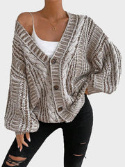 Woman wearing a brown and white striped knit cardigan partially unbuttoned over a white top