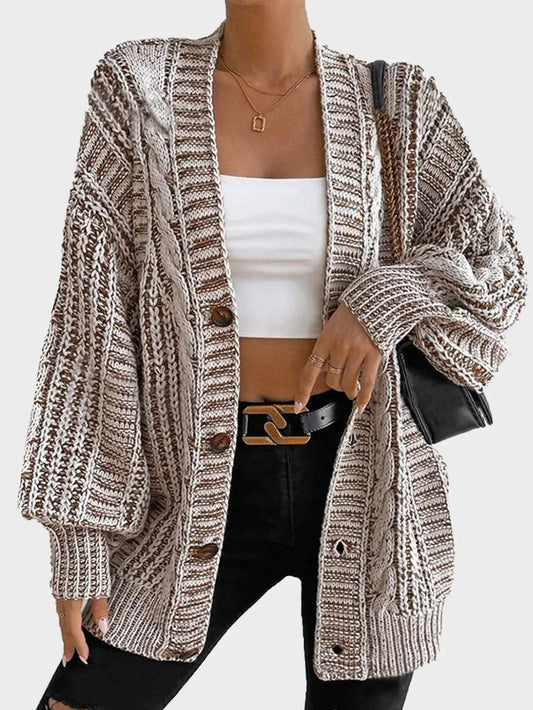 Model wearing a brown and white striped oversized knit cardigan with a white crop top and black jeans