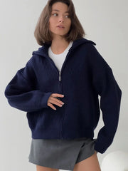 Close-up of a woman wearing a navy blue zip-up cardigan.