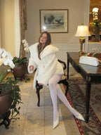 Woman wearing a white faux fur robe coat and white tights