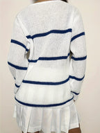 Back view of a woman wearing a white and blue striped v-neck sweater with a white pleated skirt.
