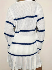 Back view of a woman wearing a white and blue striped v-neck sweater with a white pleated skirt.