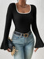 Black ribbed long-sleeve top with a white trim square neckline and flared bell sleeves, paired with blue jeans and a black handbag.