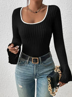 Close-up of a black ribbed long-sleeve top with a white trim square neckline and flared bell sleeves, showing the texture.