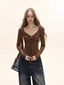 Model wearing a brown long-sleeve tie-front top and dark wash wide-leg jeans, with a brown crossbody bag.