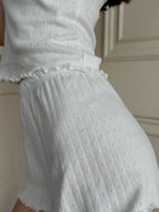 Close-up of the scalloped waistband and ribbed texture of the shorts.