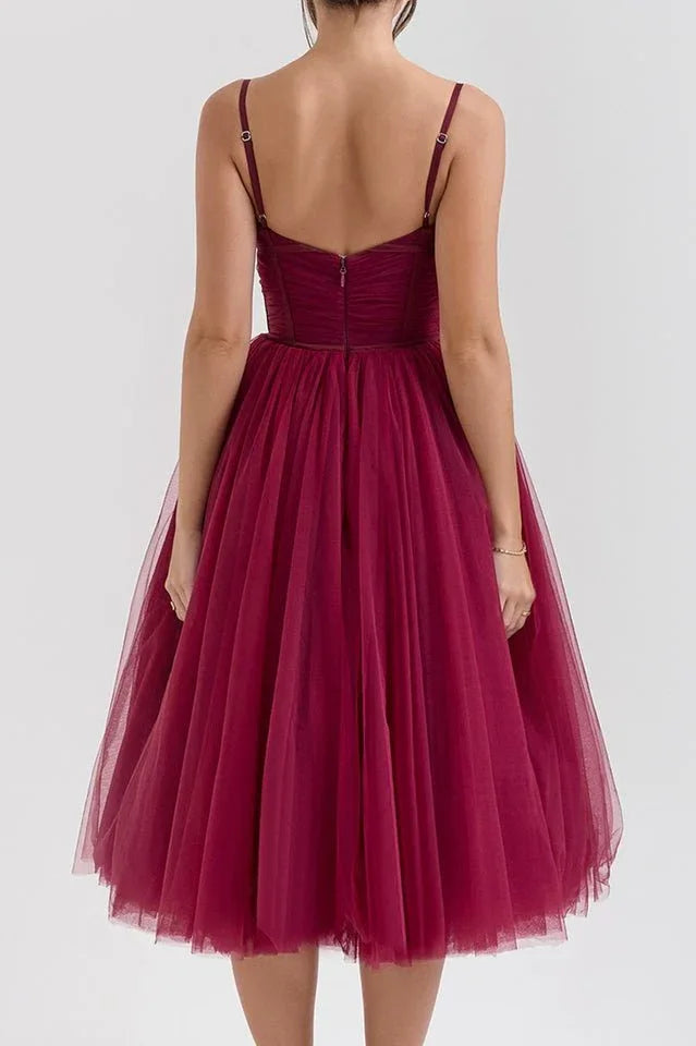 Close-up of the bodice and skirt of a burgundy tulle formal dress.