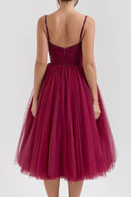 Close-up of the bodice and skirt of a burgundy tulle formal dress.