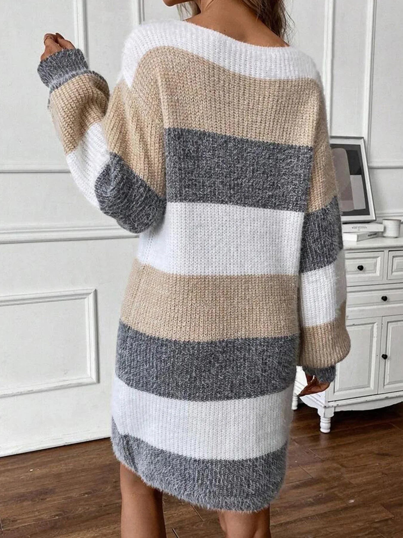 Back view of a woman in a multicolored striped knit dress.