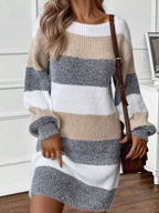 Woman wearing a long-sleeved, striped knit dress with a brown crossbody bag.