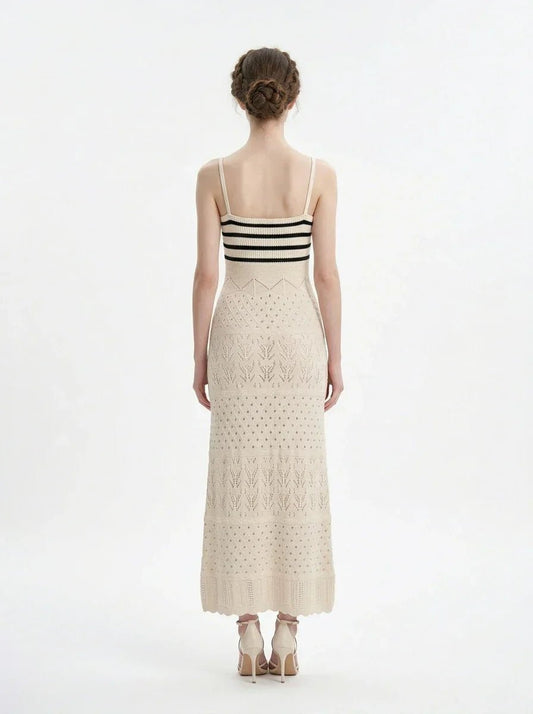 Woman wearing a cream knit maxi dress with black stripes on the bust, shown back view on a white background.