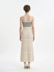 Woman wearing a cream knit maxi dress with black stripes on the bust, shown back view on a white background.