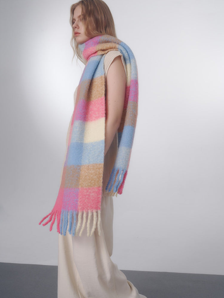 Side view of a woman showcasing the length and drape of the oversized plaid scarf.