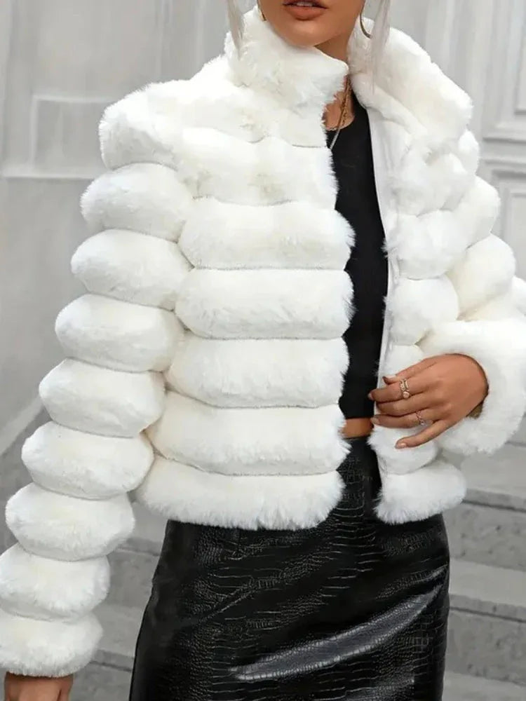 Close-up of a woman wearing a white faux fur cropped jacket over a black top, showing the texture and details.