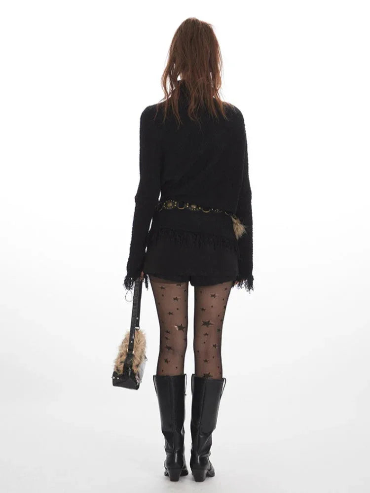 Back view of a woman wearing a black turtleneck sweater with fringe details, a fur-trimmed belt, star pattern hosiery, and black boots. Secondary image