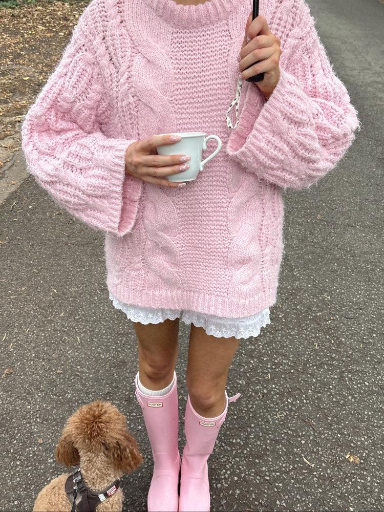 Woman wearing a pink cable knit sweater, white lace trim shorts, and pink rain boots, holding a mug and an umbrella, with a poodle dog. Main image