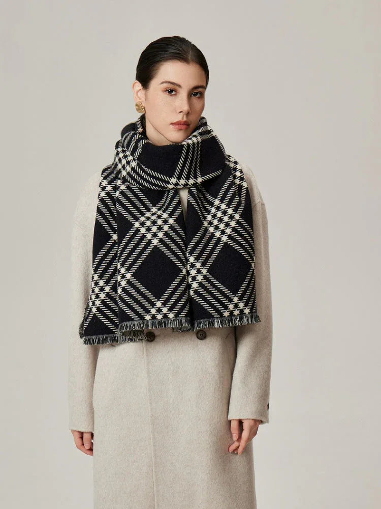 Woman in a cream coat with a black and white tartan scarf draped around her neck