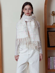 Woman in a white plaid scarf standing in front of a bookshelf