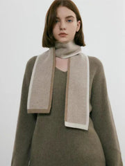 Woman in a taupe v-neck sweater and matching skirt with a scarf
