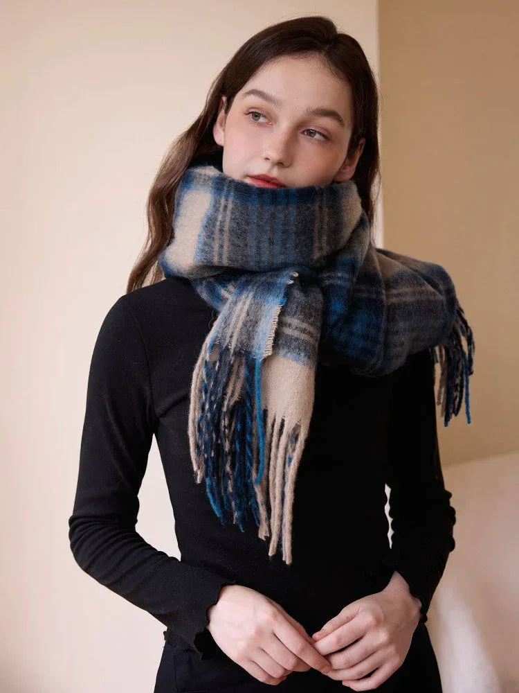Model wearing a blue and tan plaid scarf with fringe