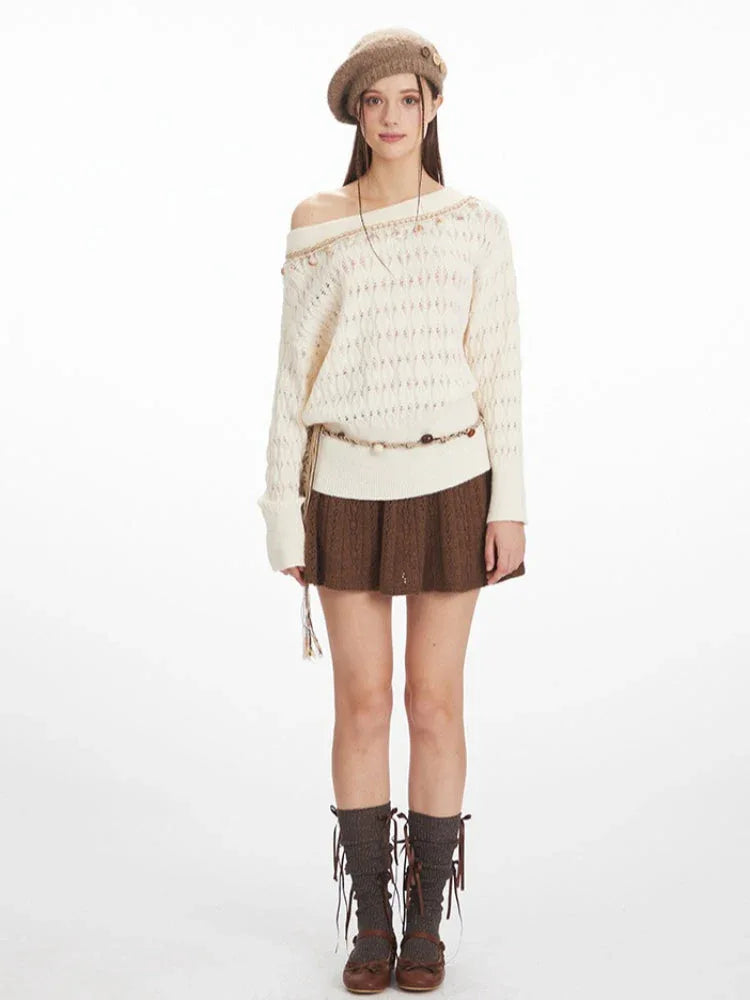 Woman wearing a cream-colored off-the-shoulder knit sweater with a brown A-line skirt, brown beret, and brown socks.