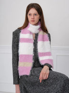 Close-up of a woman wearing a pink, white, and beige striped fuzzy scarf.