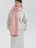 Woman facing forward wearing a pink fuzzy knit scarf and grey sweatshirt