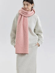 Woman facing forward wearing a pink fuzzy knit scarf and grey sweatshirt