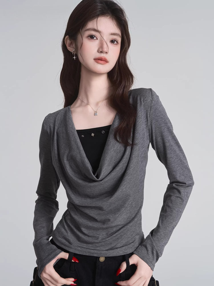Close-up of the grey long-sleeved top with draped neckline and black underlayer.