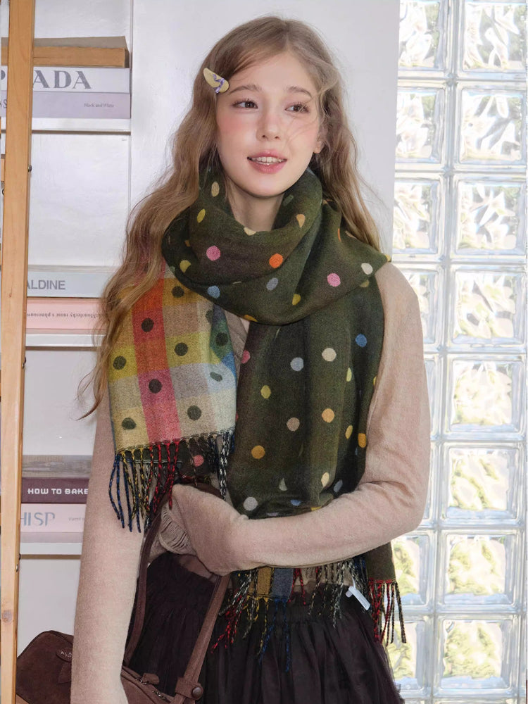 Woman wearing a dark green scarf with multicolored polka dots and a light beige cardigan.
