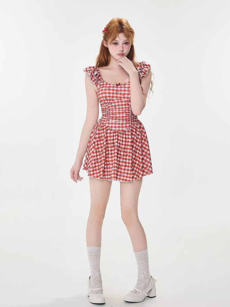Full body shot of a woman in a red and white gingham dress, white lace socks, and white platform shoes.