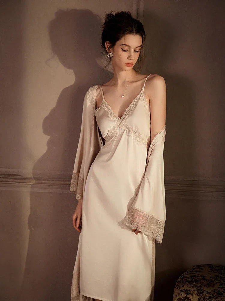 Woman wearing a cream satin slip dress with lace trim and a matching robe, standing with arms at her sides.