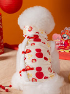Back view of a white Bichon Frise dog wearing a cream and red traditional Chinese style vest with apple and cartoon prints.