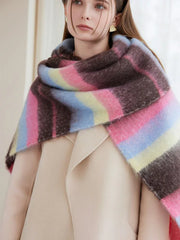 Close-up of a woman wearing a colorful striped scarf and a beige coat.