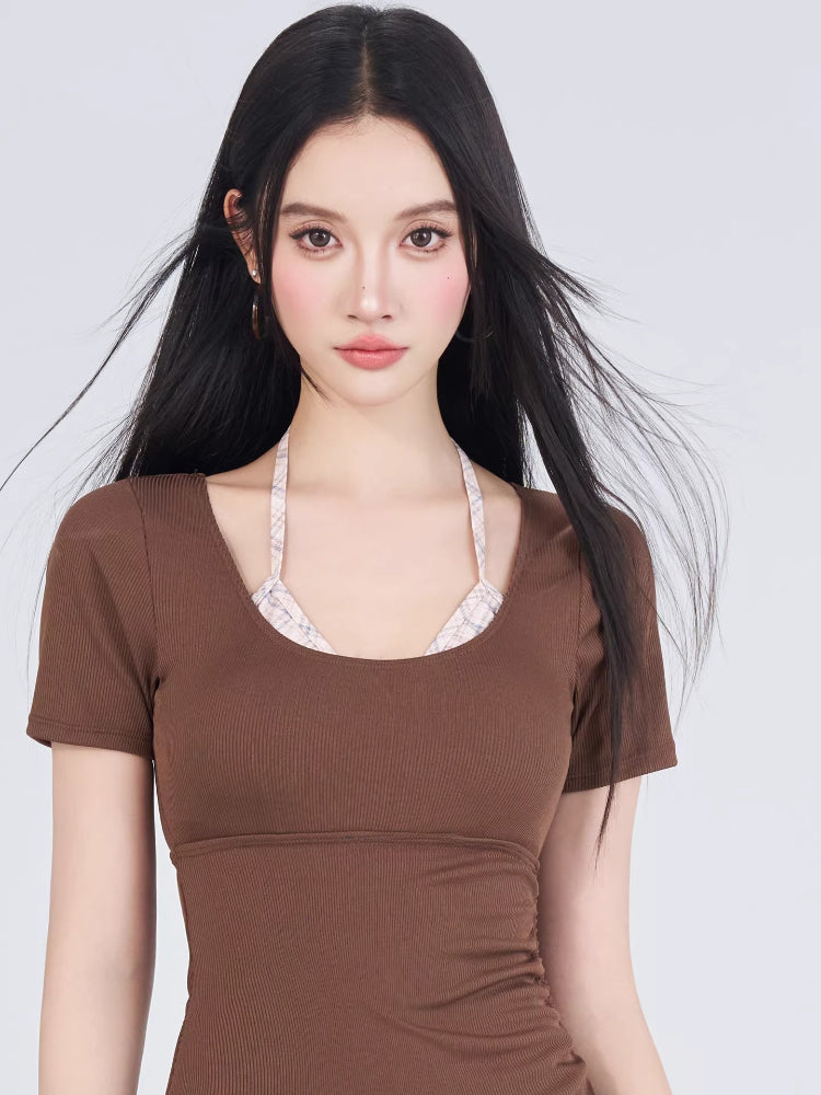 Close-up of the woman's upper body, showing the brown ribbed knit swimsuit with a plaid trim peeking out at the neckline.
