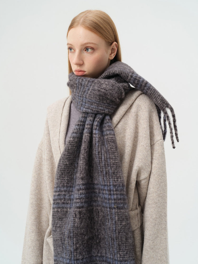 Close-up of the model's face and the textured knit plaid scarf.